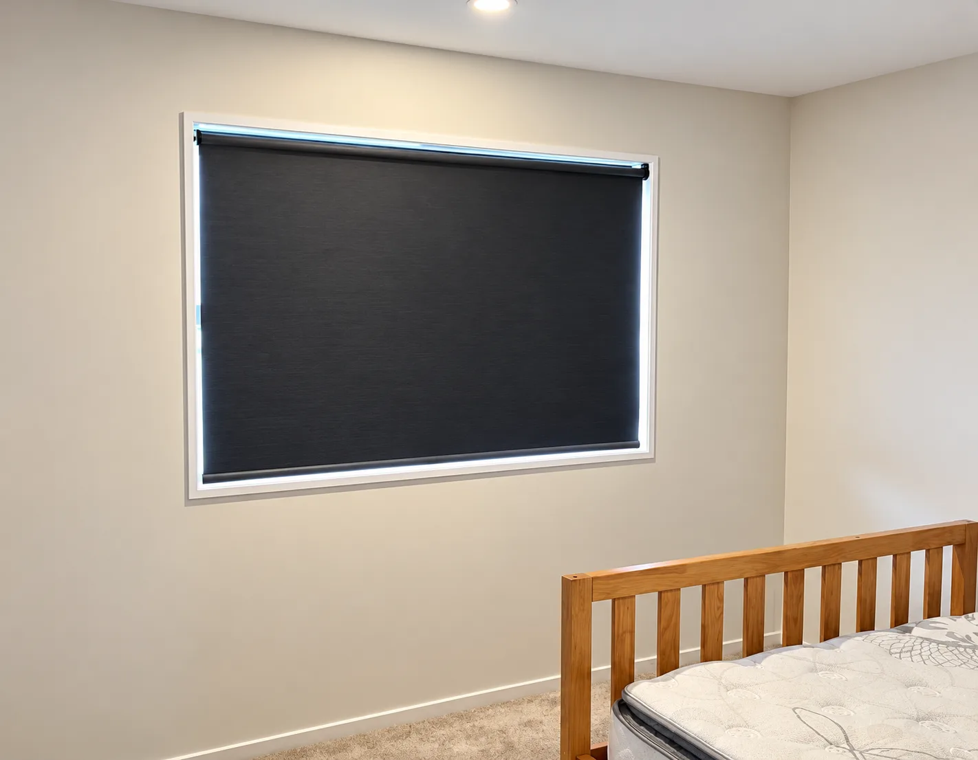 Bedroom with a charcoal roller blind