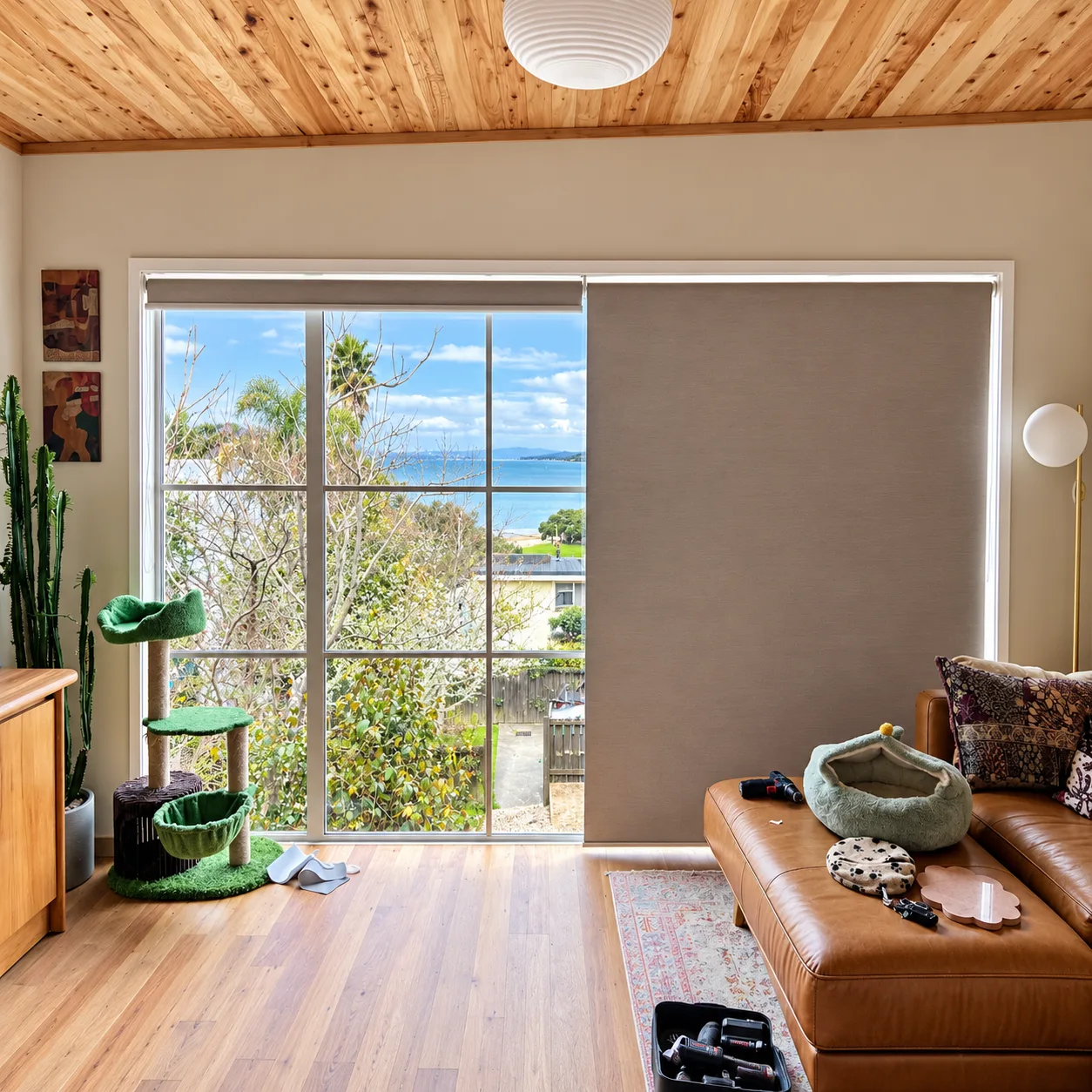 Coastal living room with a roller blind half drawn over a sea view