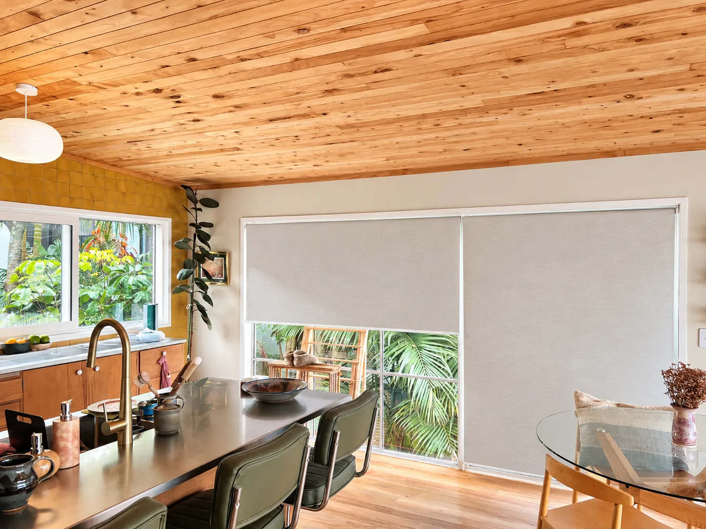 Kitchen and dining room with sunscreen roller blinds on the sliding doors