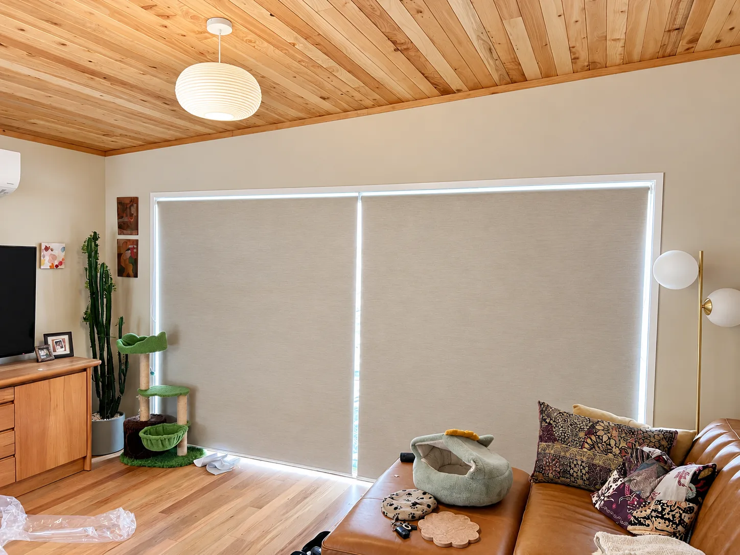 Living room with light-filtering roller blinds and a timber ceiling