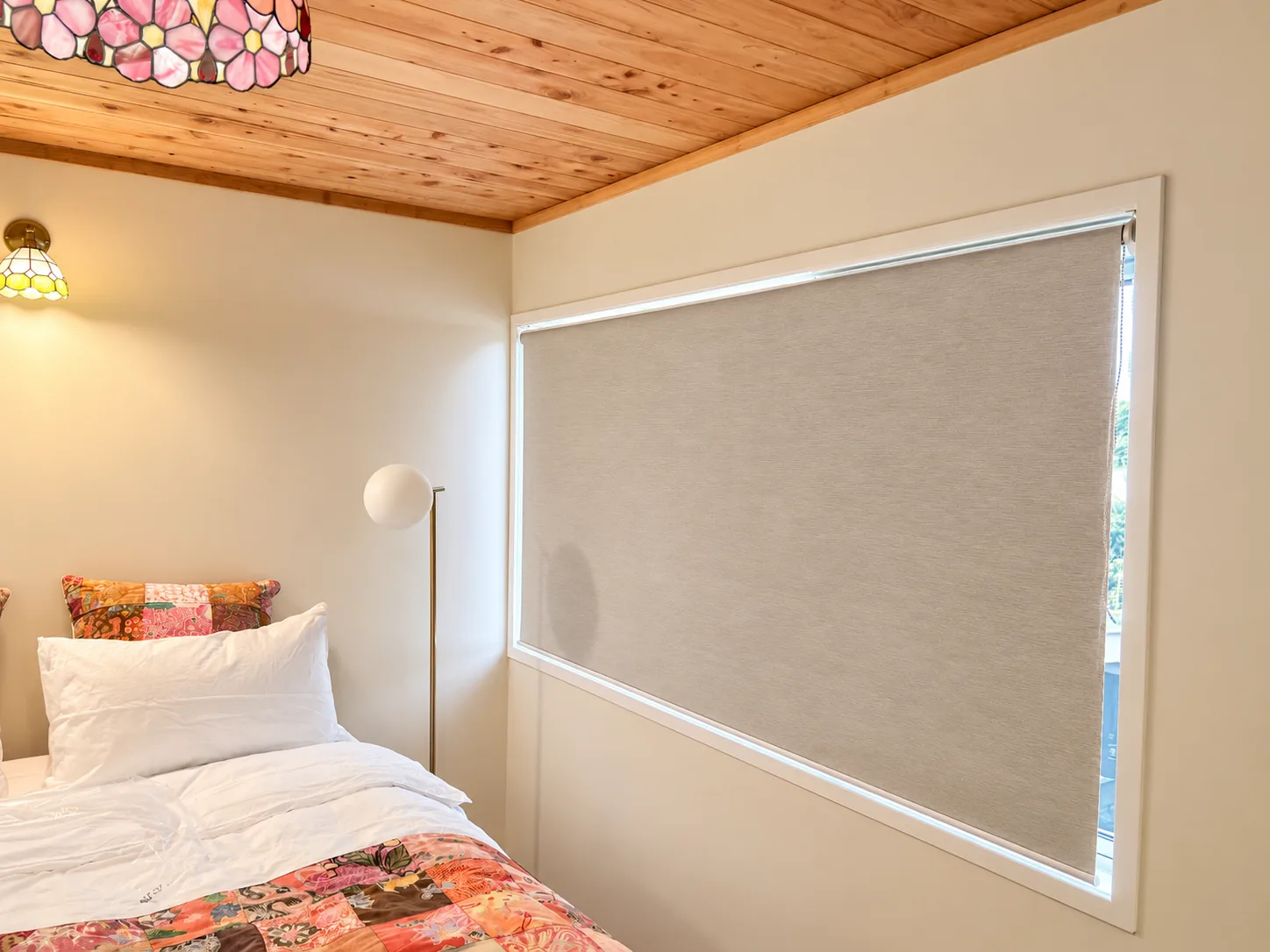 Bedroom with a light-filtering roller blind